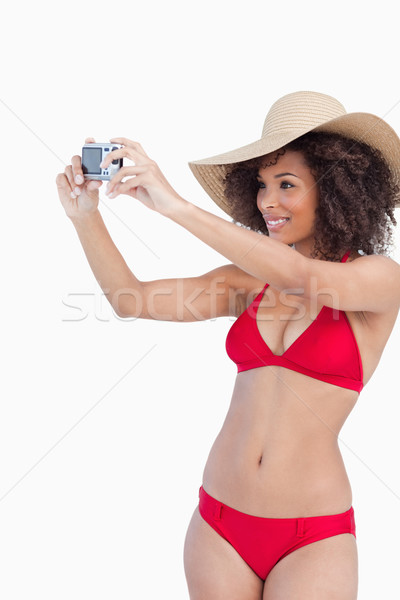 Young woman in beachwear photographing herself against a white background Stock photo © wavebreak_media