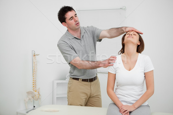 Serious practitioner placing his hand on the forehead of a woman in an office Stock photo © wavebreak_media