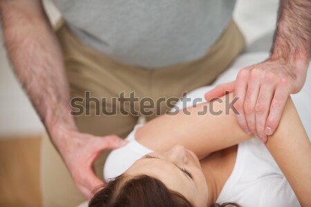 Serious doctor pressing on the knees of a patient in a room Stock photo © wavebreak_media