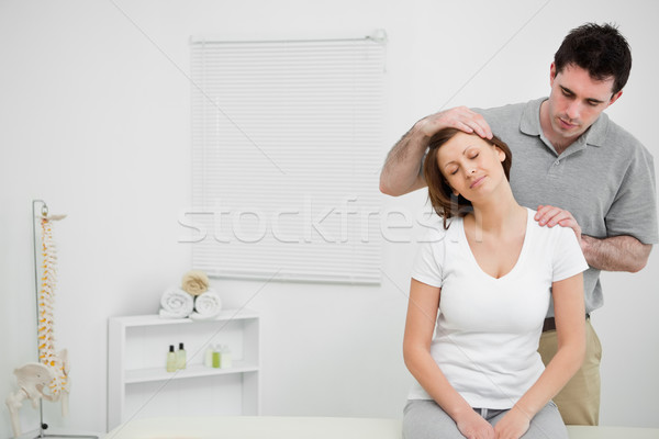 Doctor examining the neck of his patient while stretching it in a room Stock photo © wavebreak_media