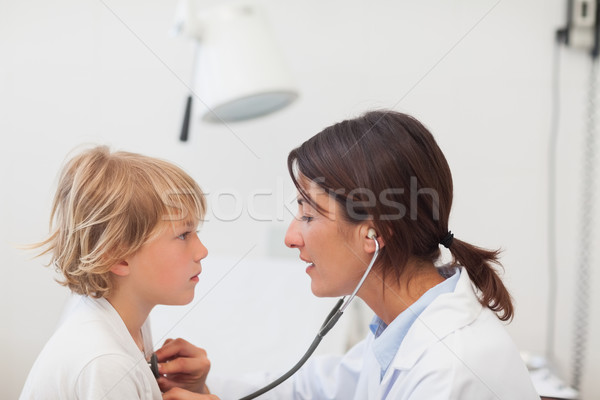 Stock photo: Doctor auscultating a child with a stethoscope in examination room