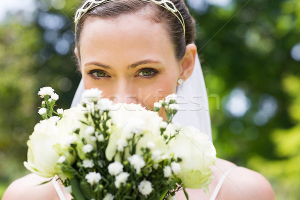 Bride peeking over bouquet in garden Stock photo © wavebreak_media