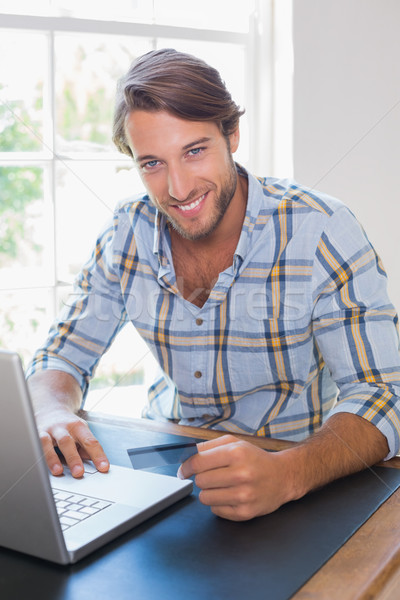 Foto stock: Sonriendo · casual · hombre · usando · la · computadora · portátil · tienda · línea