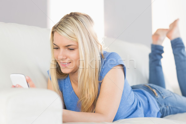Stock photo: Relaxed beautiful woman text messaging in living room