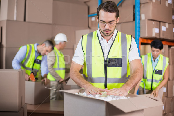 Stock photo: Warehouse workers in yellow vests preparing a shipment