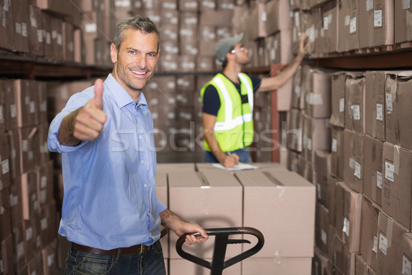 Warehouse manager smiling at camera with trolley Stock photo © wavebreak_media