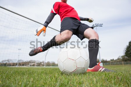 Stock photo: Fit player kicking football