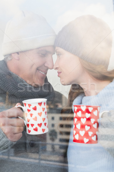 Happy couple in warm clothing holding mugs Stock photo © wavebreak_media