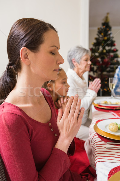 Extended family praying before christmas dinner Stock photo © wavebreak_media