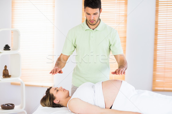 Relaxed pregnant woman getting reiki treatment Stock photo © wavebreak_media