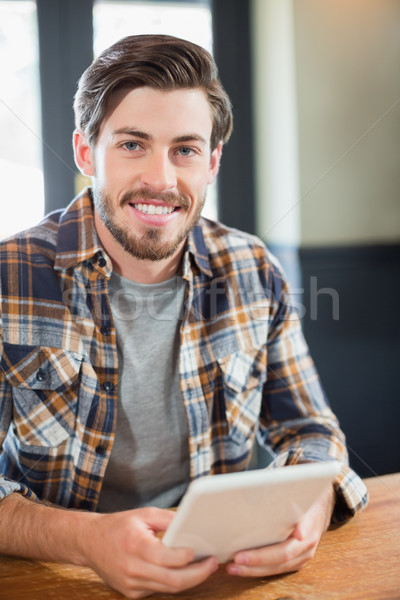 Handsome young man holding tablet pc Stock photo © wavebreak_media