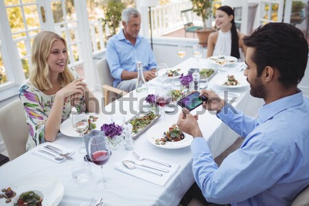 Group of friends interacting with each other while having meal together Stock photo © wavebreak_media