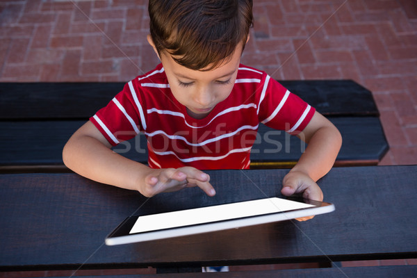 Boy touching digital tablet while sitting at table in school Stock photo © wavebreak_media