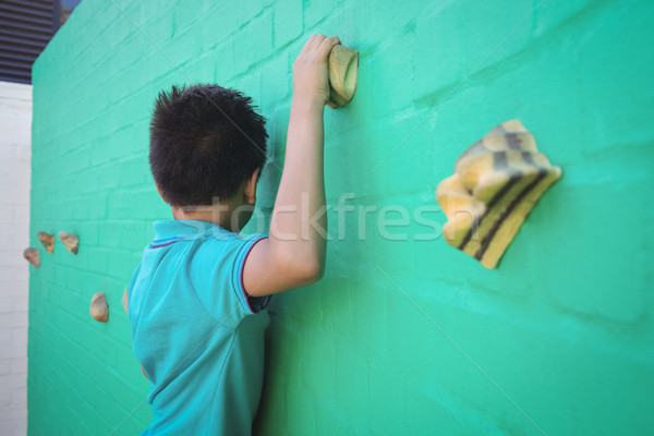 Vista laterale ragazzo climbing muro verde mano Foto d'archivio © wavebreak_media