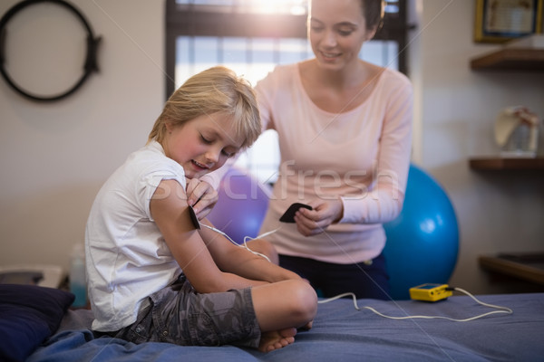 Female therapist positioning electrodes on arm of boy Stock photo © wavebreak_media