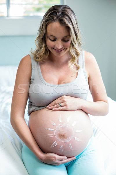 Pregnant woman applying cream on her belly Stock photo © wavebreak_media