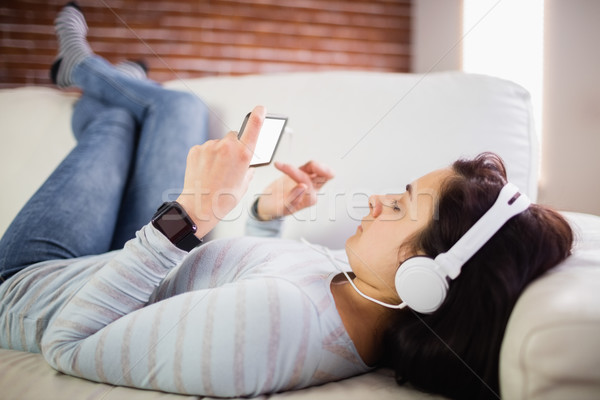 Femme écouter de la musique maison couché canapé casque [[stock_photo]] © wavebreak_media