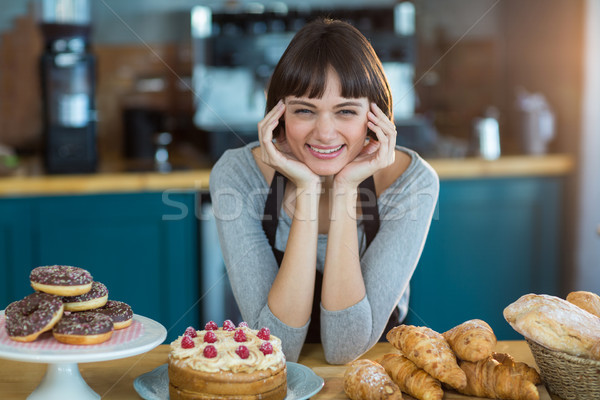 Portret chelneriţă şedinţei contracara alimente dulce tabel Imagine de stoc © wavebreak_media