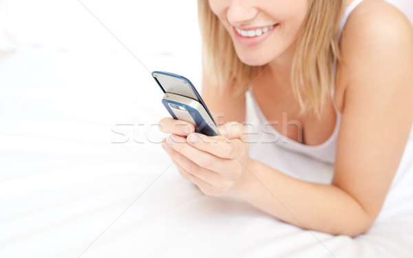 Close-up of a blond woman giving a text message lying down on be Stock photo © wavebreak_media