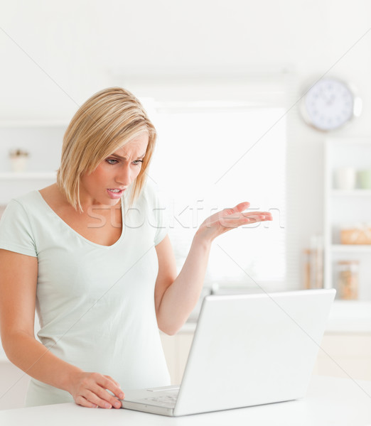 Angry woman looking at notebook in a kitchen without having any clue what to do Stock photo © wavebreak_media