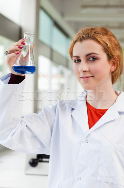 Portrait of a chemist holding a blue liquid while looking at the camera Stock photo © wavebreak_media