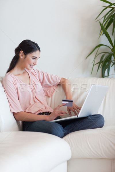 Stock photo: Portrait of a woman shopping online in her living room