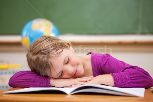 Stock photo: Schoolgirl sleeping on her desk in a classroom