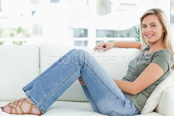 Mujer sesión sofá brazo superior sonriendo Foto stock © wavebreak_media