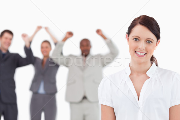 Smiling saleswoman with celebrating colleagues behind her against a white background Stock photo © wavebreak_media
