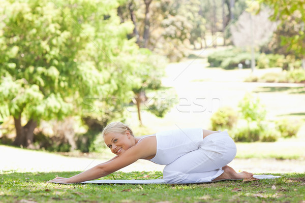 Side view of a young woman doing stretches on the lawn Stock photo © wavebreak_media