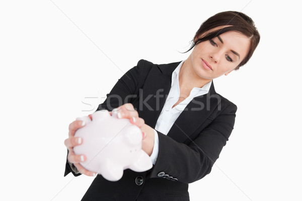 Young woman in suit emptying a piggy bank against white background Stock photo © wavebreak_media