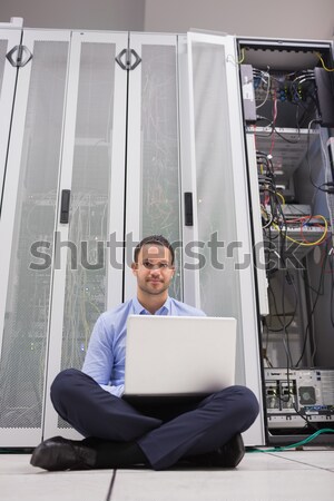 Man sitting on floor using laptop to check servers in data center Stock photo © wavebreak_media
