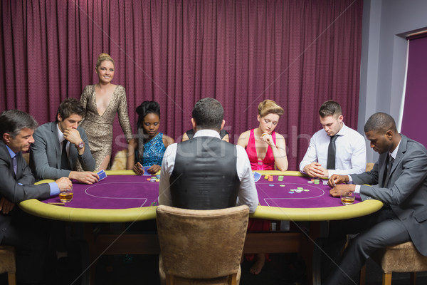 People sitting at the casino table with woman standing and smiling  Stock photo © wavebreak_media