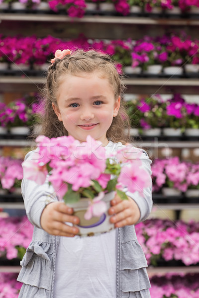 Little girl smiling and holding a flower pot in garden center Stock photo © wavebreak_media