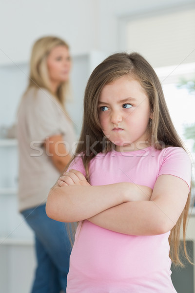 Little girl looking angry in the kitchen with mother in background Stock photo © wavebreak_media