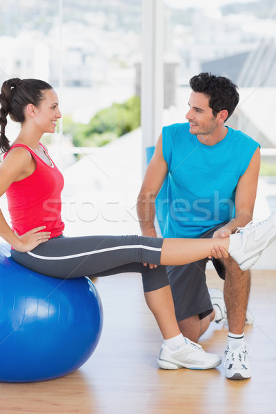 Stock photo: Male trainer helping woman with her exercises at gym