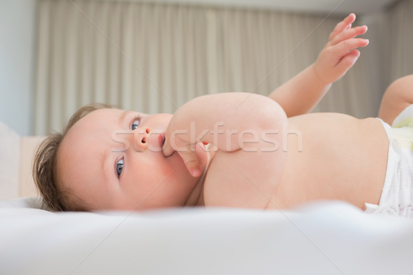 Baby with finger in mouth lying on crib Stock photo © wavebreak_media