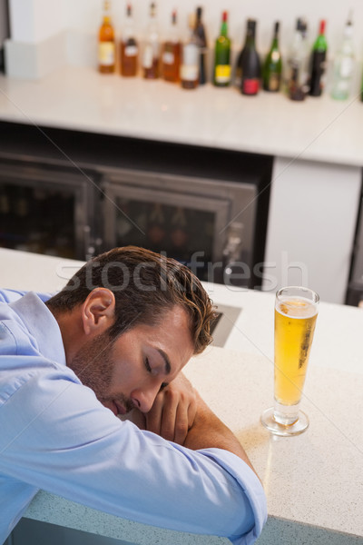 Drunk businessman sleeping beside glass of beer Stock photo © wavebreak_media