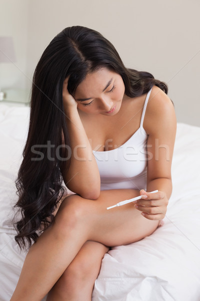 Frau Sitzung Bett schauen Schwangerschaftstest home Stock foto © wavebreak_media