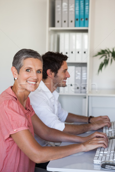 Stock photo: Casual business team working at desk using computers