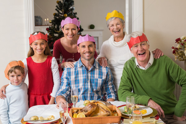 Happy extended family in party hat at dinner table Stock photo © wavebreak_media