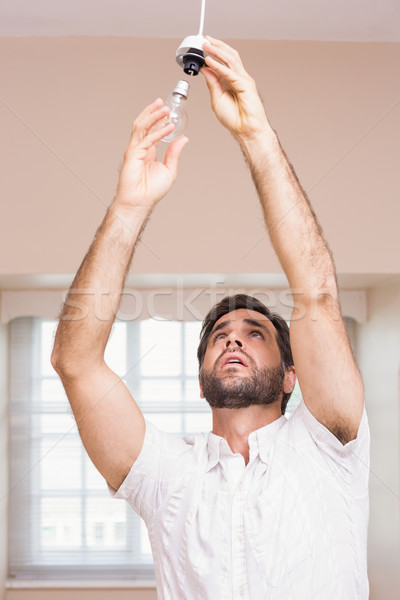 Stock photo: Man replacing the light bulb