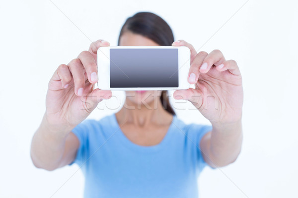 Brunette woman taking a selfie with her smartphone Stock photo © wavebreak_media