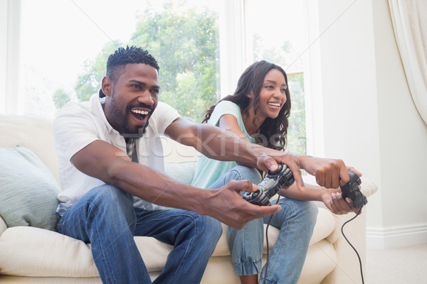 Stock photo: Happy couple on the couch playing video games