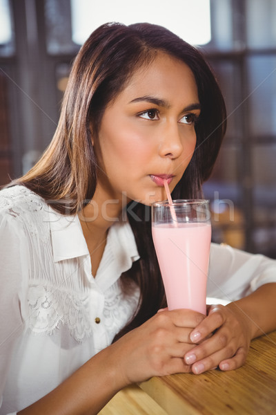 A beautiful woman drinking a pink milkshake Stock photo © wavebreak_media