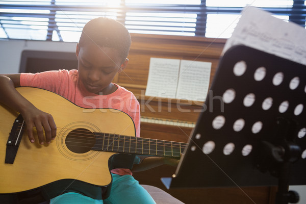 Boy playing guitar while sitting in classroom Stock photo © wavebreak_media