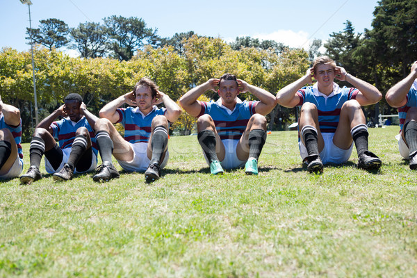 Portrait of rugby players exercising at grassy field Stock photo © wavebreak_media