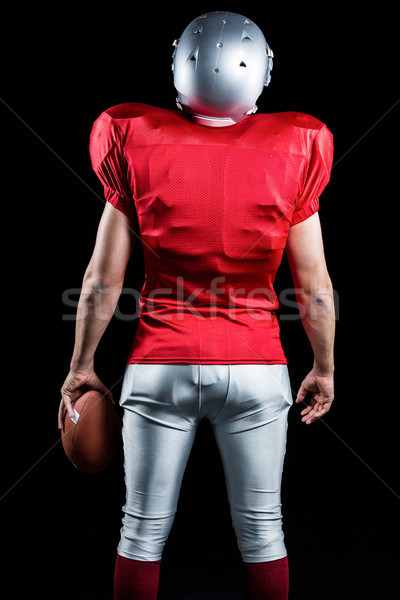 Stock photo: Rear view of American football player with ball