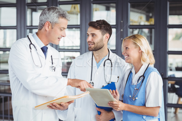 Senior doctor discussing with coworkers while standing  Stock photo © wavebreak_media