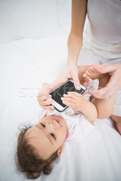 Midsection of mother holding mobile phone while playing with bab Stock photo © wavebreak_media